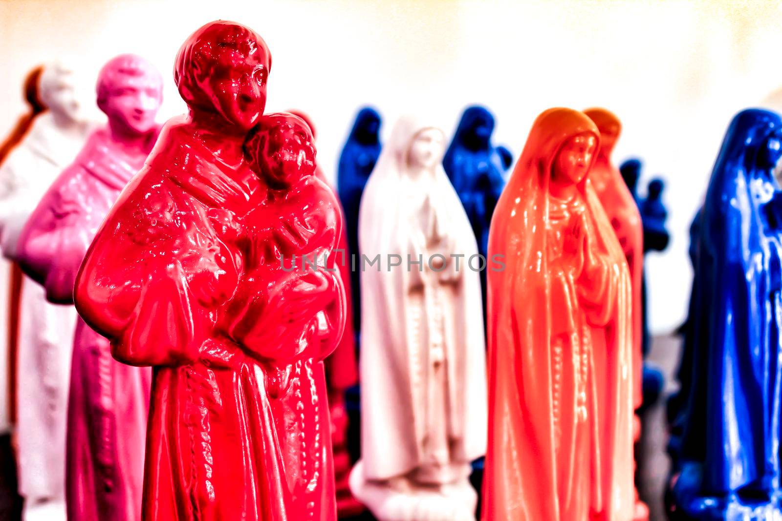 Colorful and typical souvenirs of Saint Anthony figurines and Fatima virgin in a showcase in Lisbon, Portugal