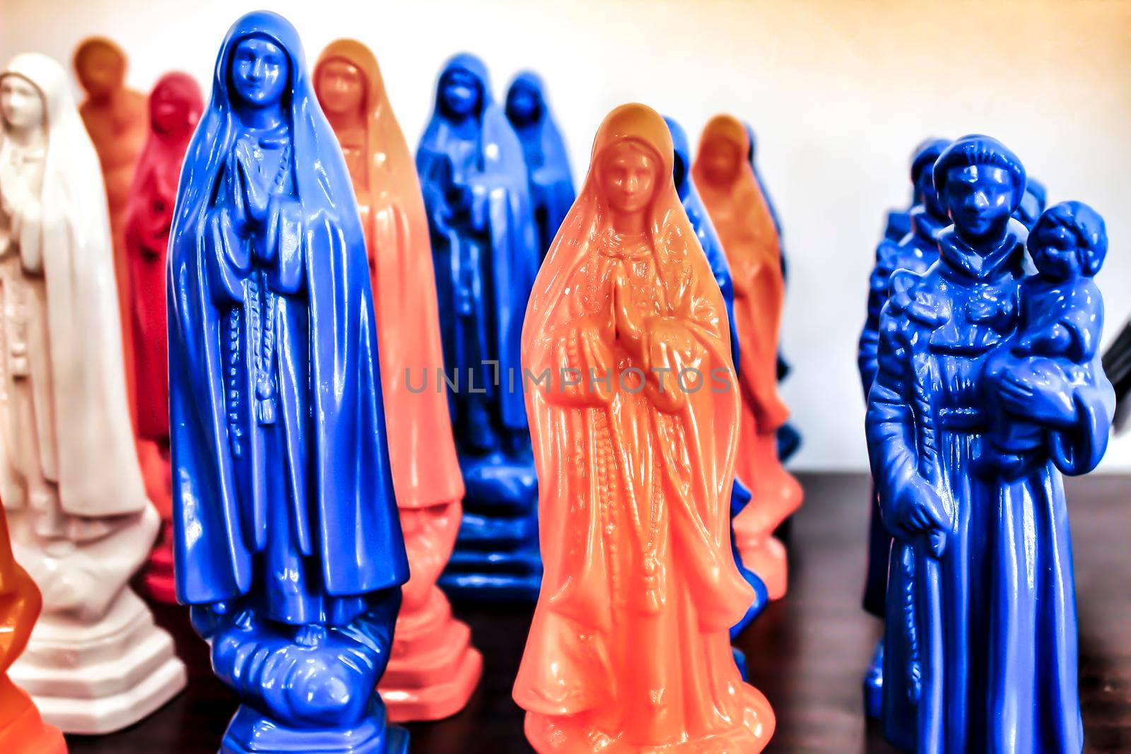 Colorful and typical souvenirs of Saint Anthony figurines and Fatima virgin in a showcase in Lisbon, Portugal
