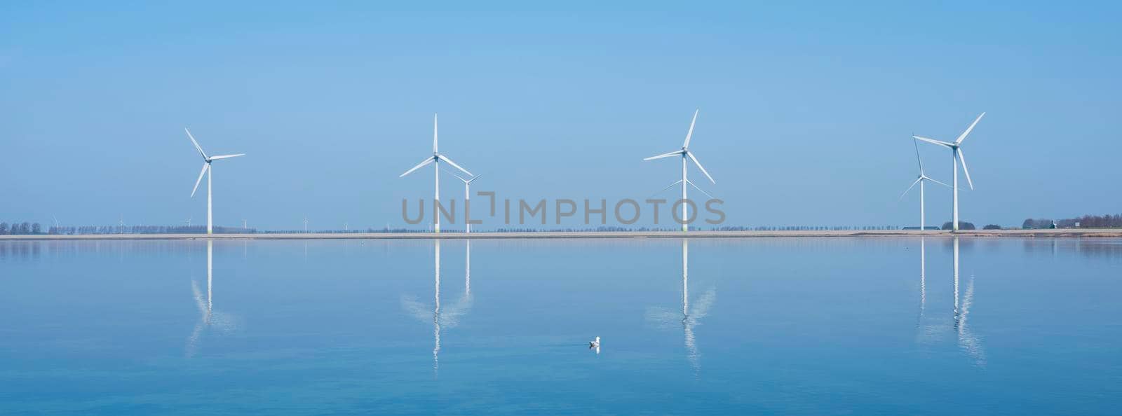 wind turbines reflected in water near philipsdam in dutch province of zeeland by ahavelaar
