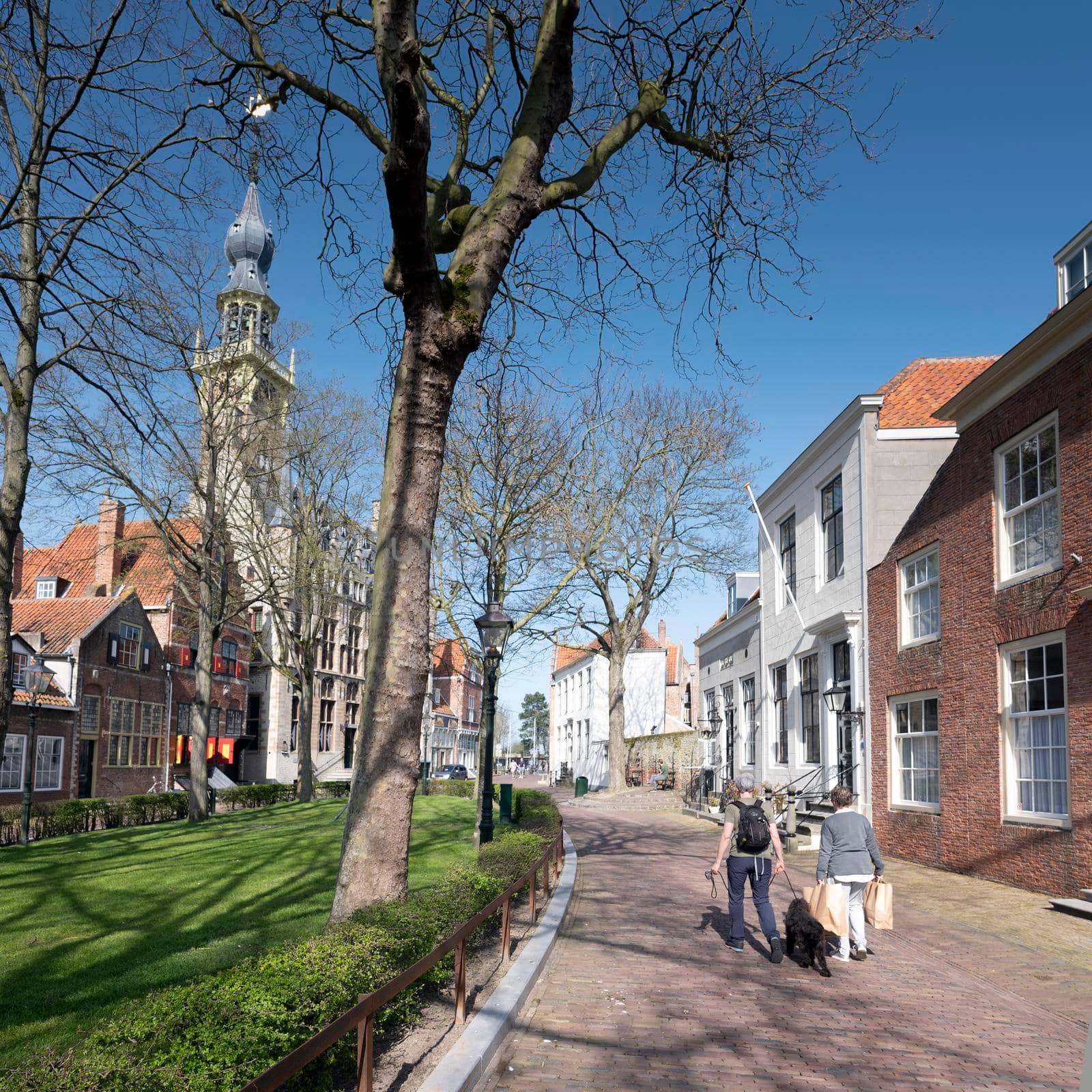 Veere, Netherlands, 31 march 2021: visitors on market square in old dutch town of Veere in dutch province of zeeland in the netherlands on sunny day early spring