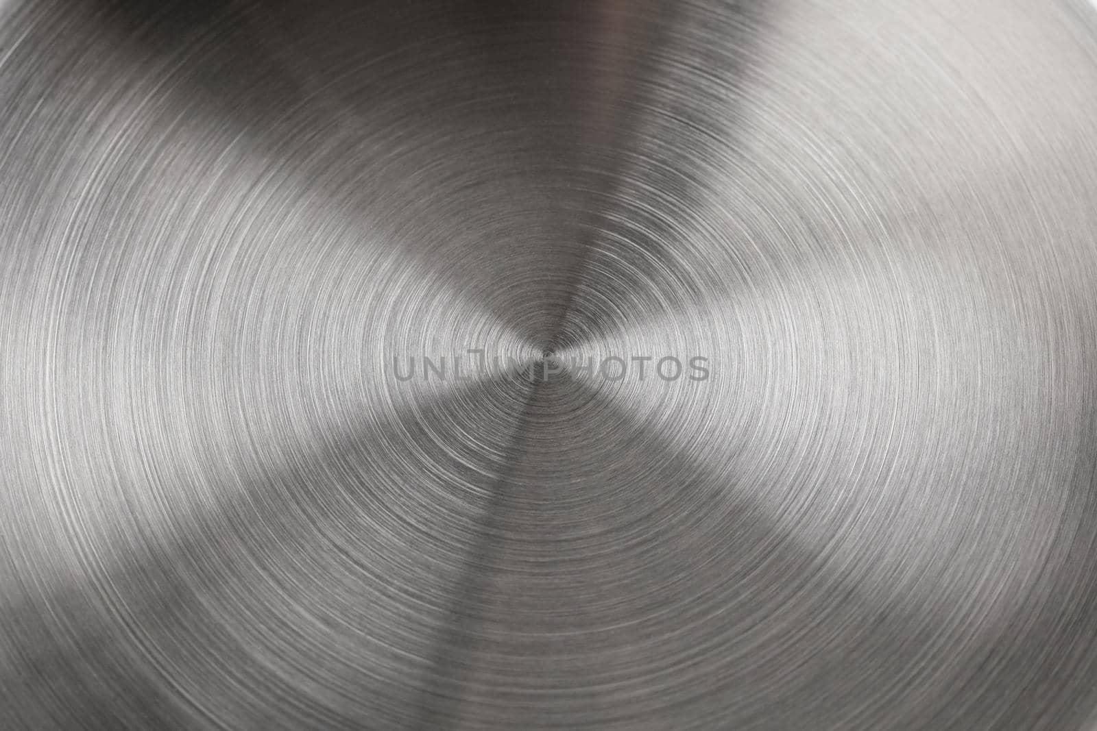 real concentric brushed stainless steel background of new saucepan bottom, close-up with selective focus