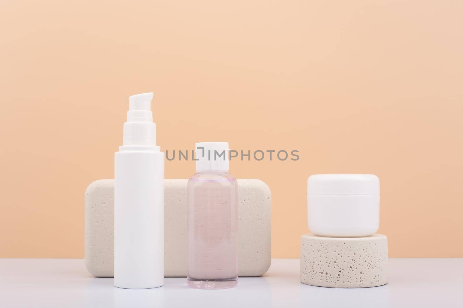 Set of natural organic beauty products for daily skin care with beige podiums against beige background. by Senorina_Irina
