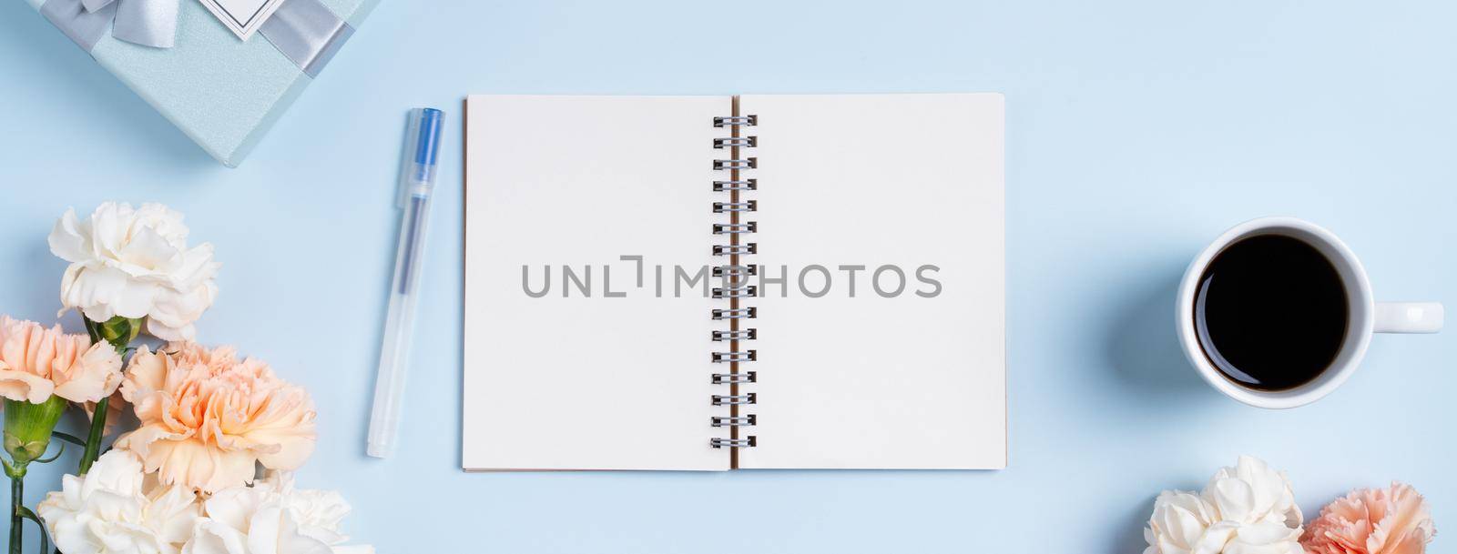Design concpet of Mother's Day greeting with carnation flower, holiday gift idea and notebook diary on mother's desk background.