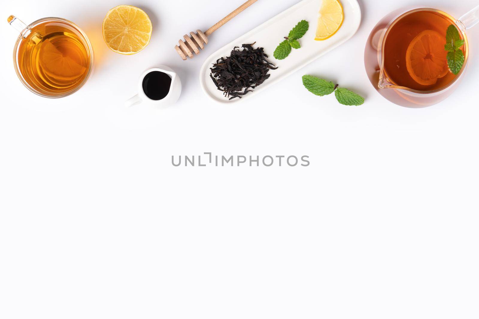 Design concept top view of honey black tea with yellow lemon and mint leaf on white table background.