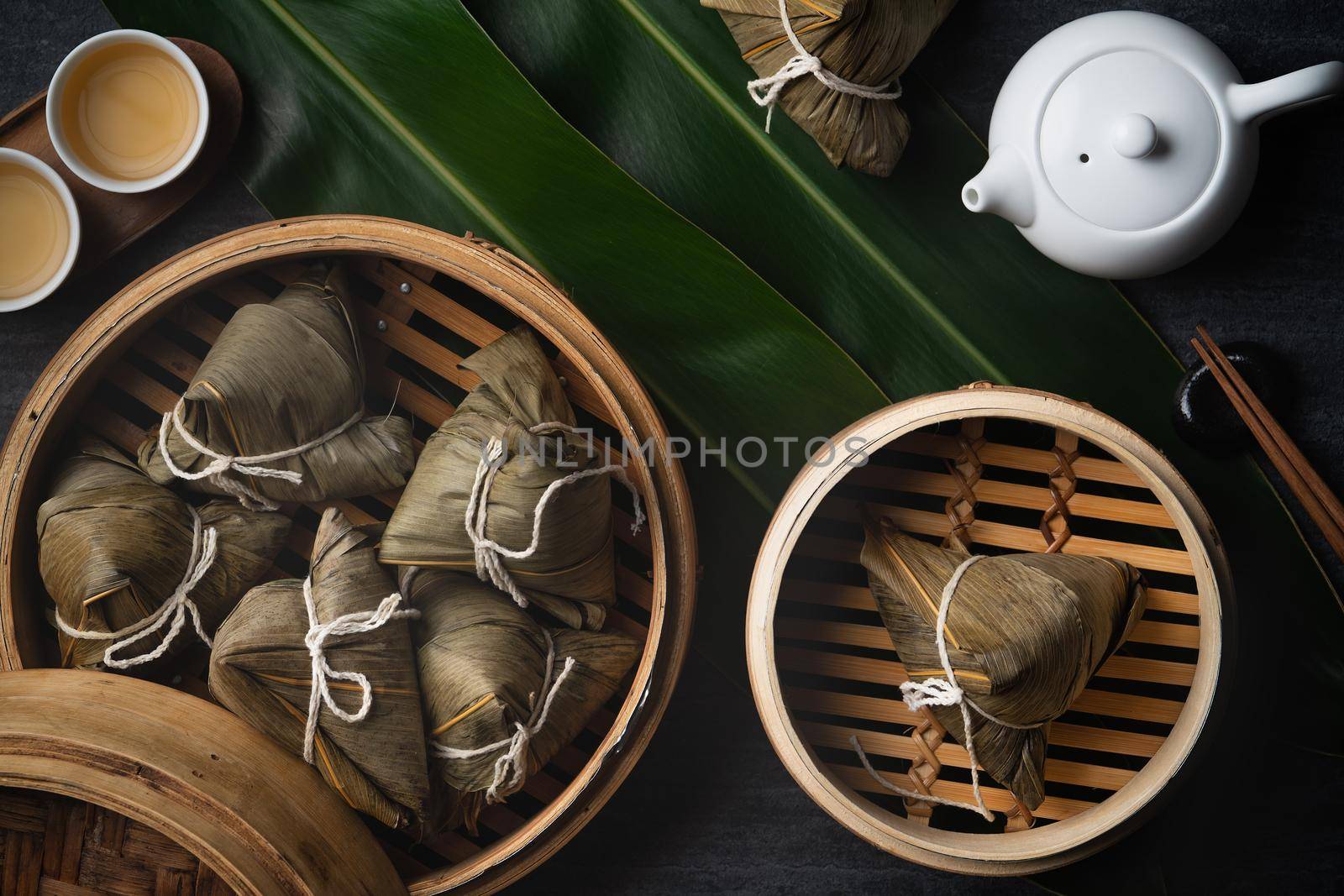 Zongzi rice dumpling top view for Chinese traditional Dragon Boat Festival (Duanwu Festival) over dark black slate background.