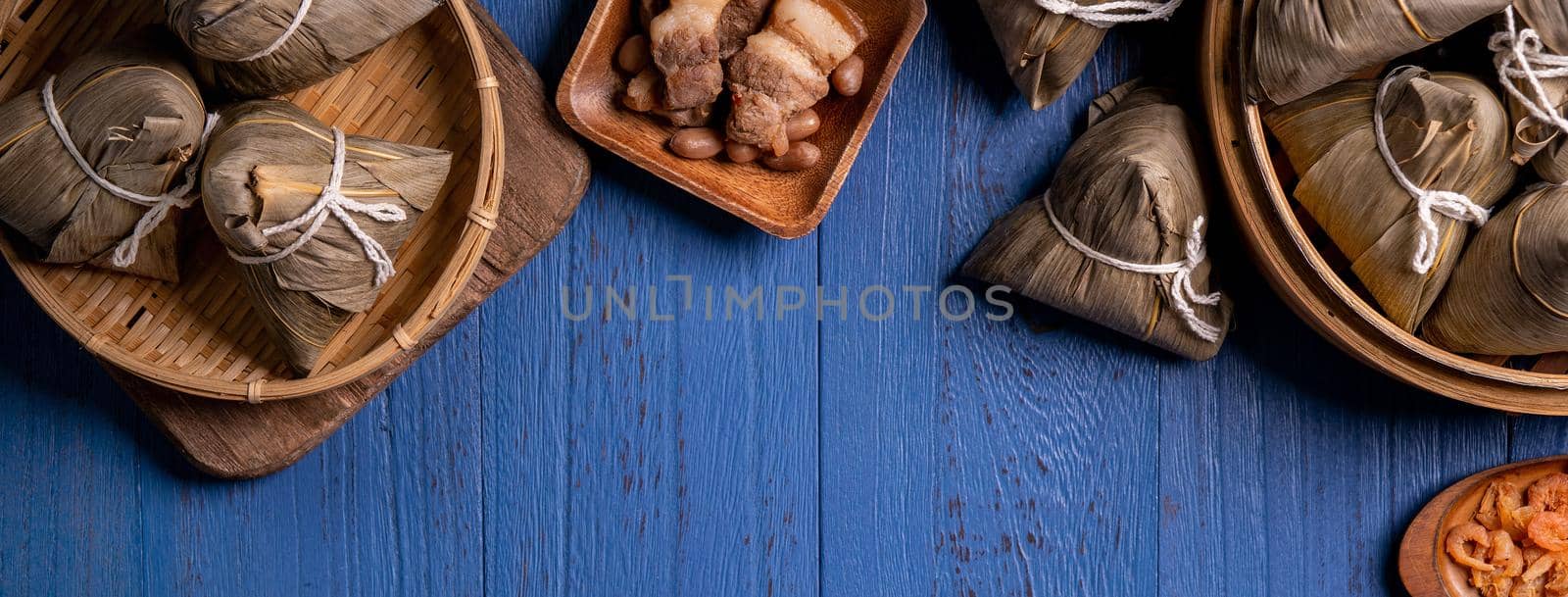 Zongzi rice dumpling with ingredients top view for Chinese traditional Dragon Boat Festival (Duanwu Festival) over blue wooden table background.