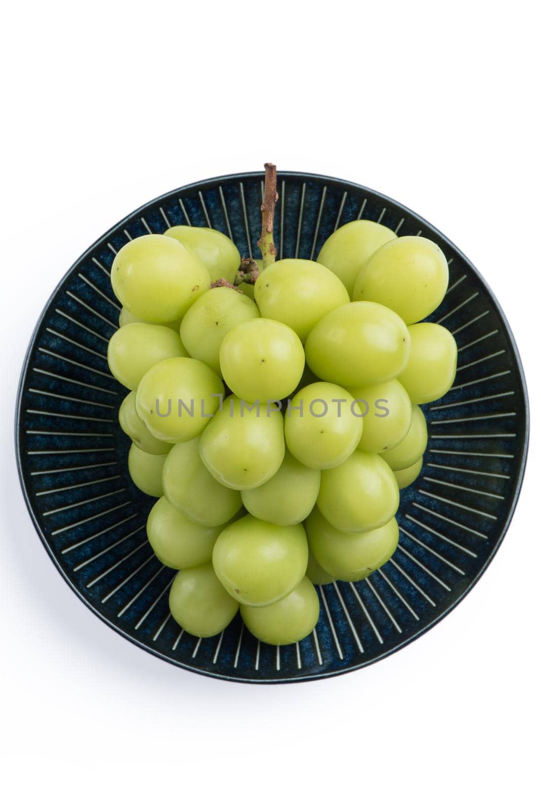 Close up of beautiful a bunch of Shine Muscat green grape on a blue plate isolated on white background, clipping path cut out.