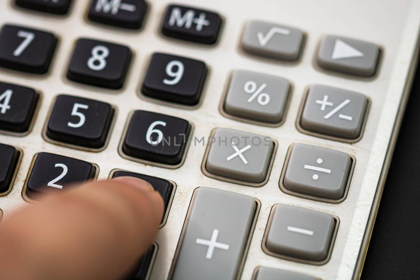 Finger pushing the button calculator. Tax concept, accounting concept. Unrecognizable man hands holding and using a calculator