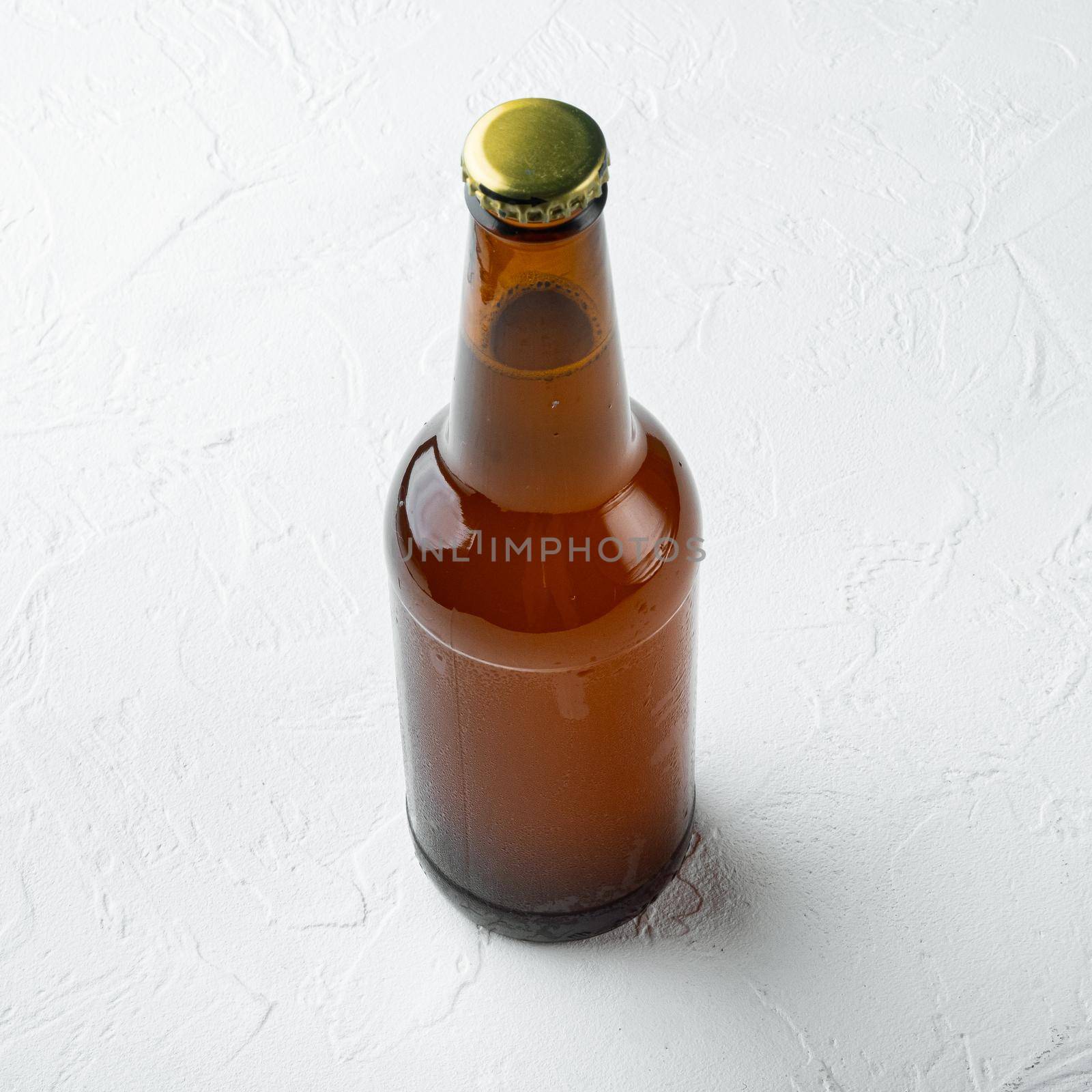 Glass bottles of beer, on white stone surface, square format by Ilianesolenyi