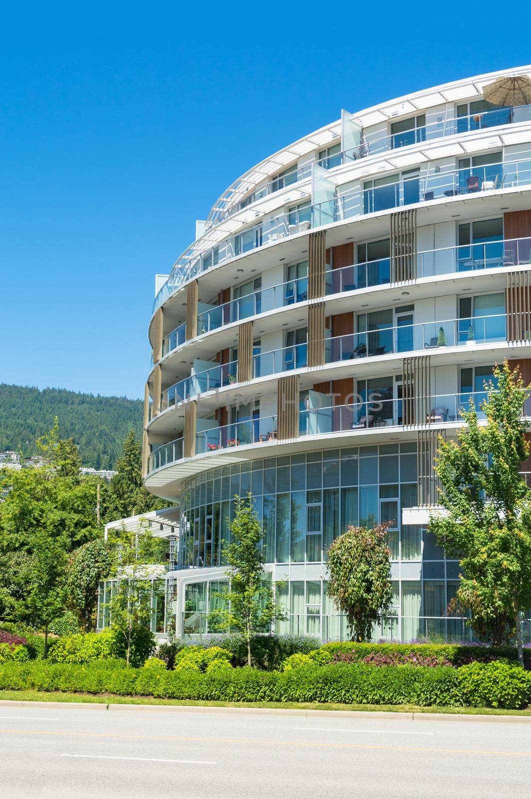 Round shaped front facade of residential building on mountain and blue sky background