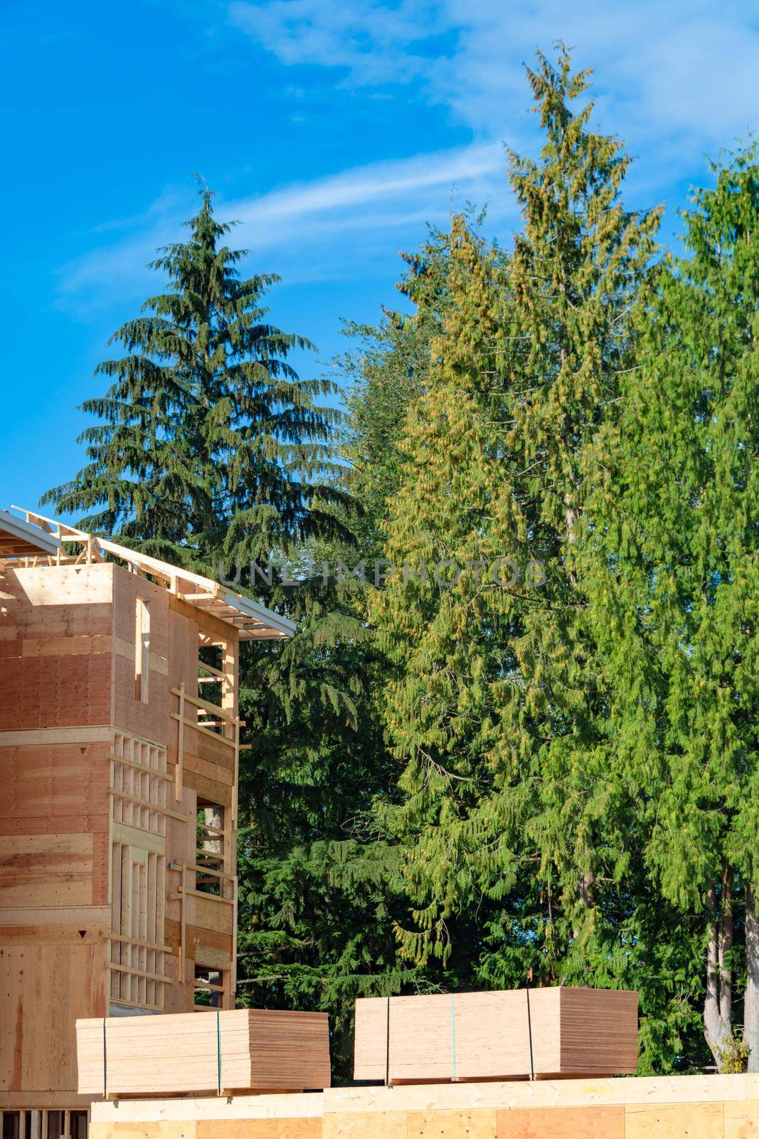 Apartment building under construction with two trunks of timber stored beside