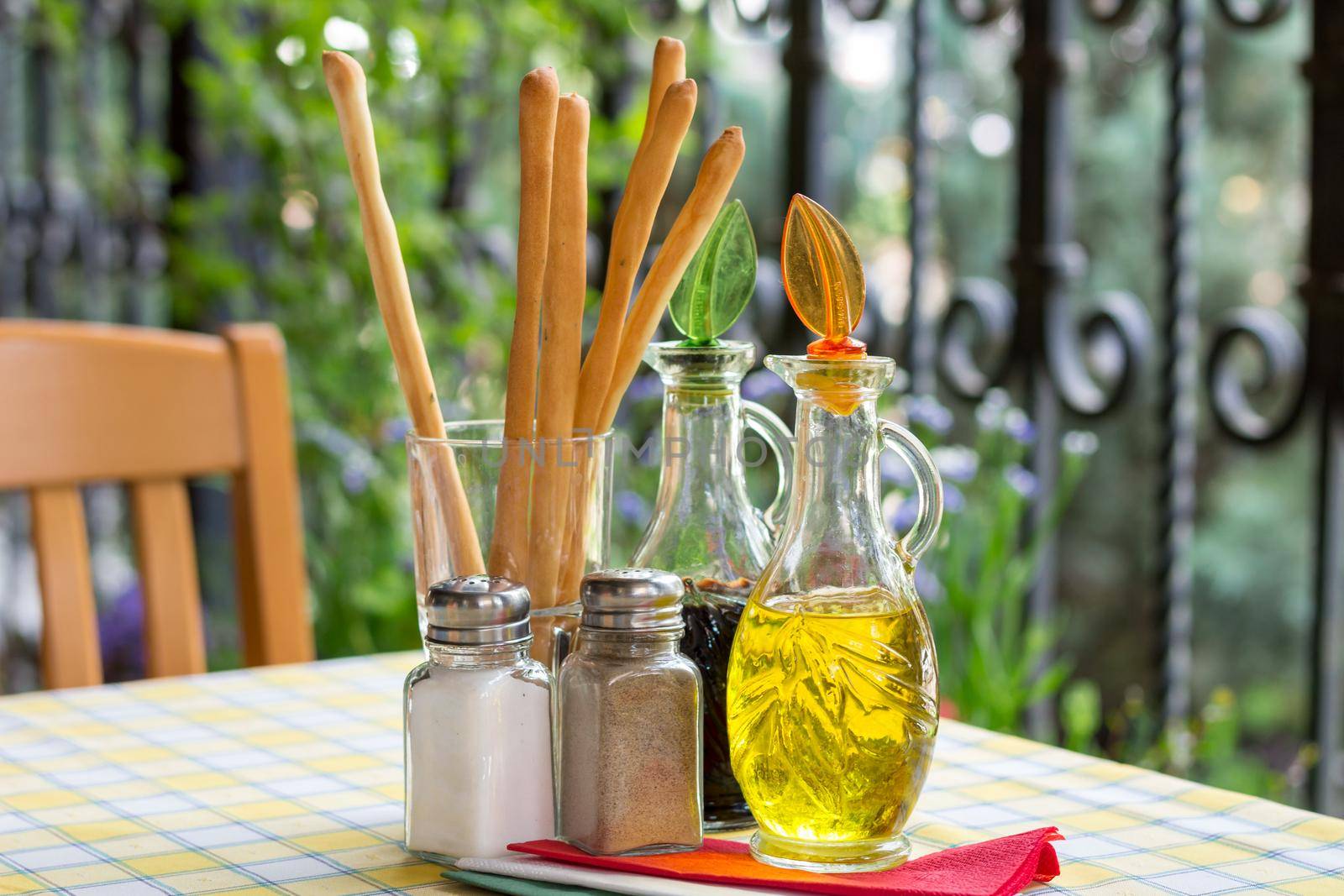 Italian serving. Table set of olive oil, bread sticks, salt, pepper by VeraVerano