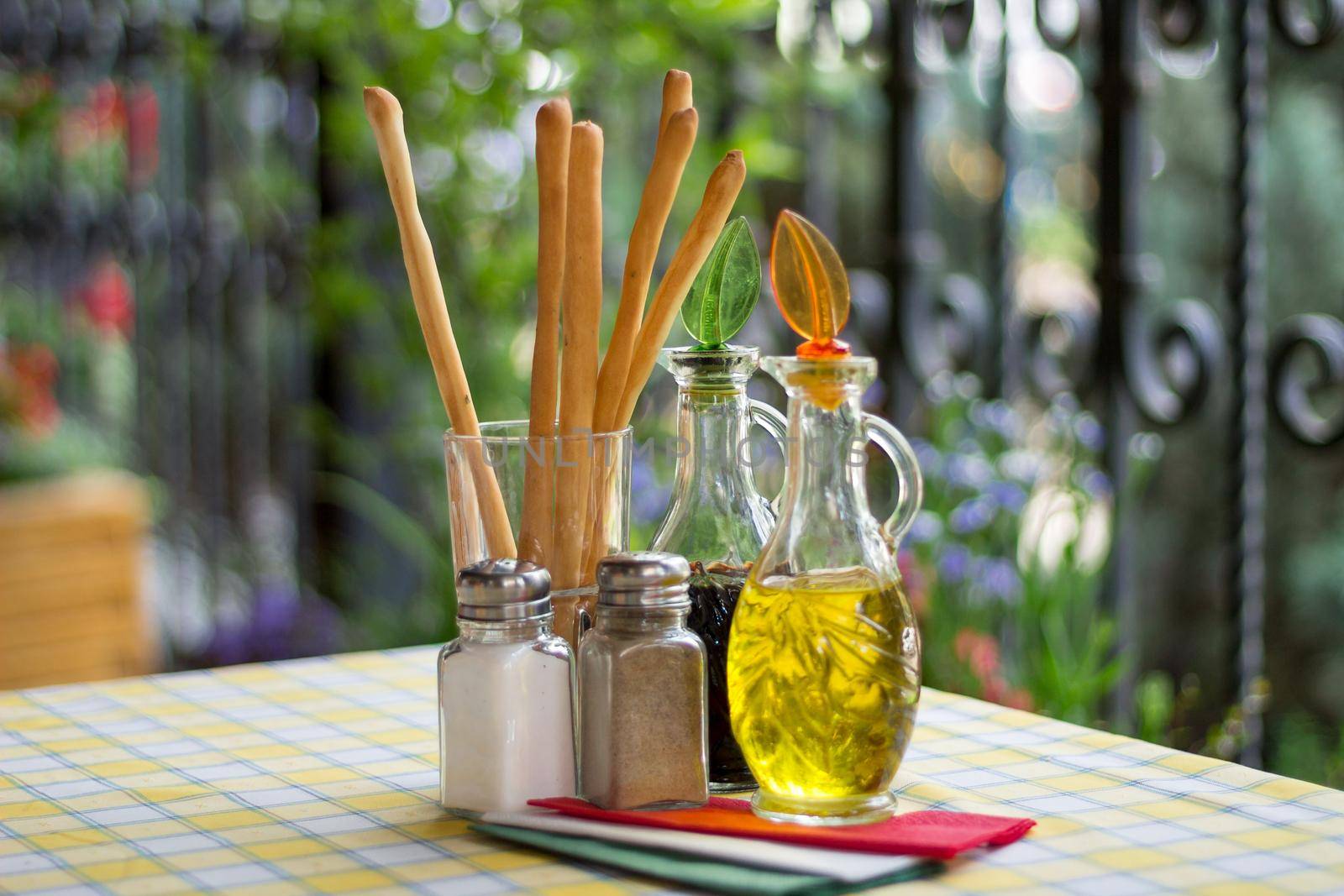 Italian serving. Table set of olive oil, bread sticks, salt and pepper by VeraVerano