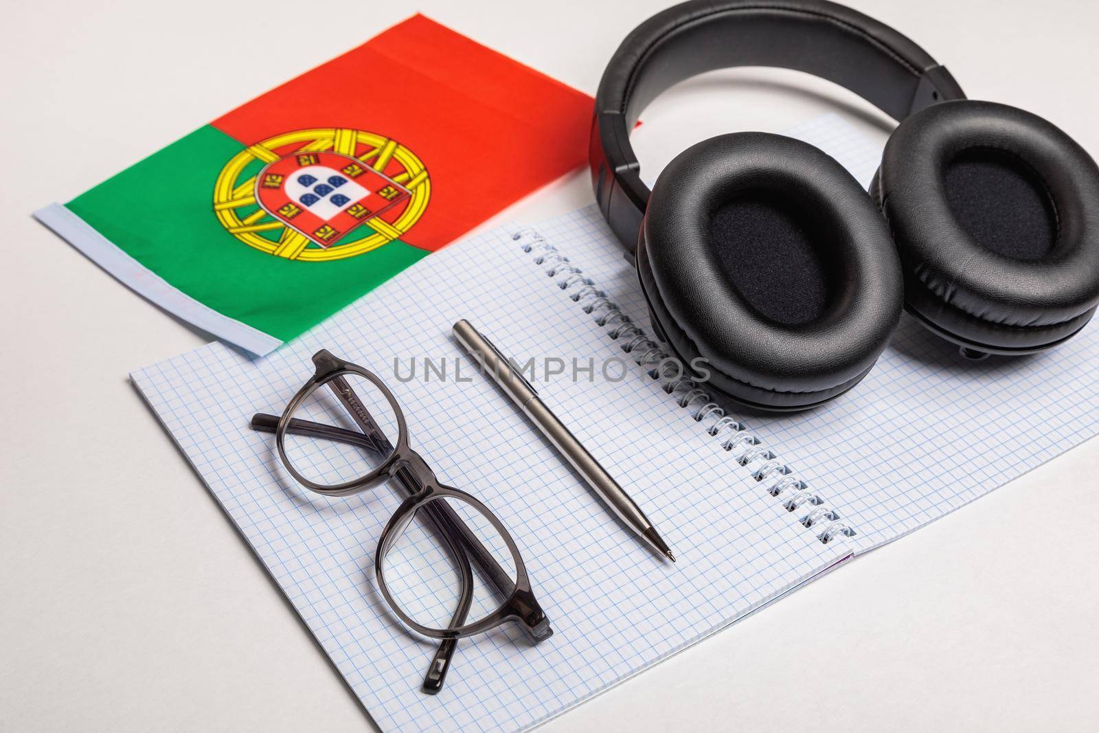 Learn foreign languages in Portugal with audio recordings and headphones. Notepad, glasses, pen.