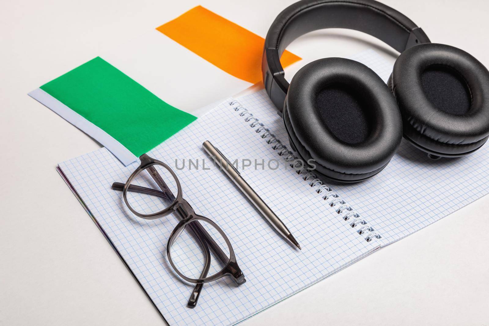 Learn foreign languages in Ireland with audio recordings and headphones. Notepad, glasses, pen.