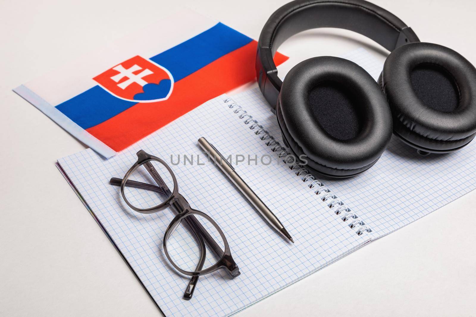 Learning foreign languages in Slovakia using audio recordings and headphones. Notepad, glasses, pen.