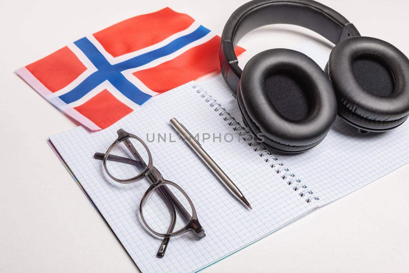 Learning foreign languages in Norway with audio recordings and headphones. Notepad, glasses, pen.
