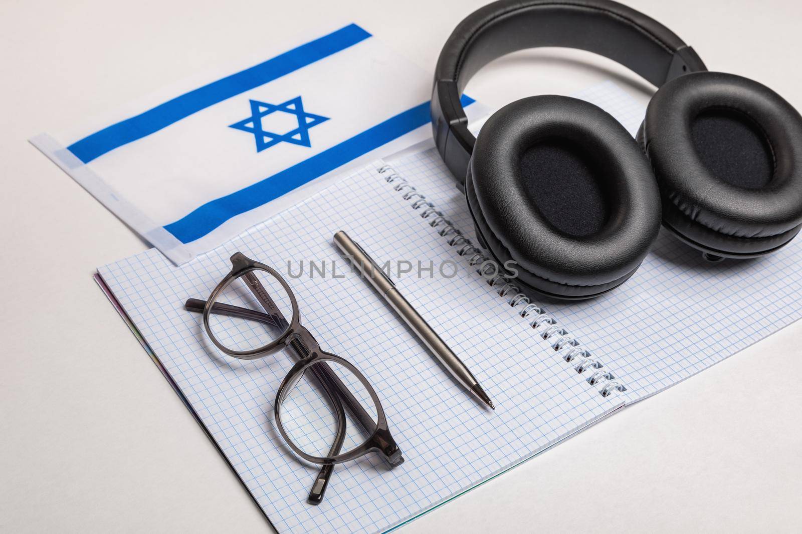 Learning foreign languages in Israel with audio recordings and headphones. Notepad, glasses, pen.
