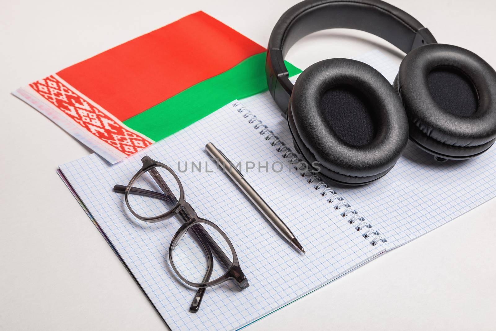 Learning foreign languages in Belarus with the help of audio recordings and headphones. Notepad, glasses, pen.