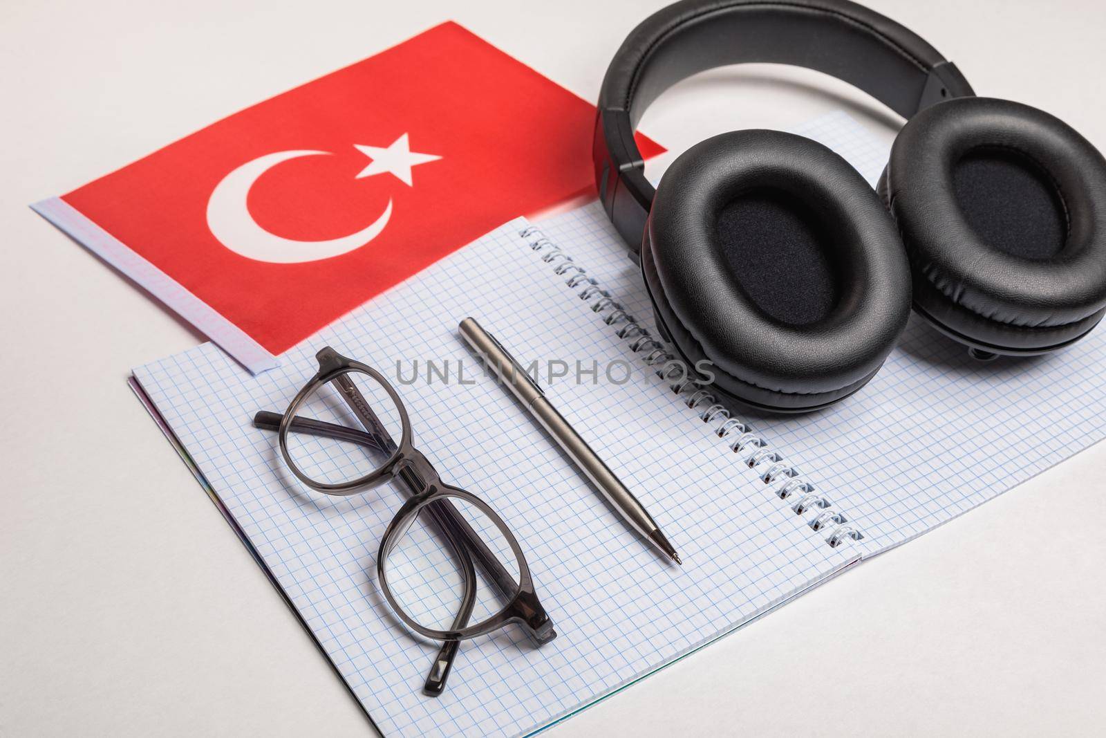 Learning foreign languages in Turkey with audio recordings and headphones. Notepad, glasses, pen.