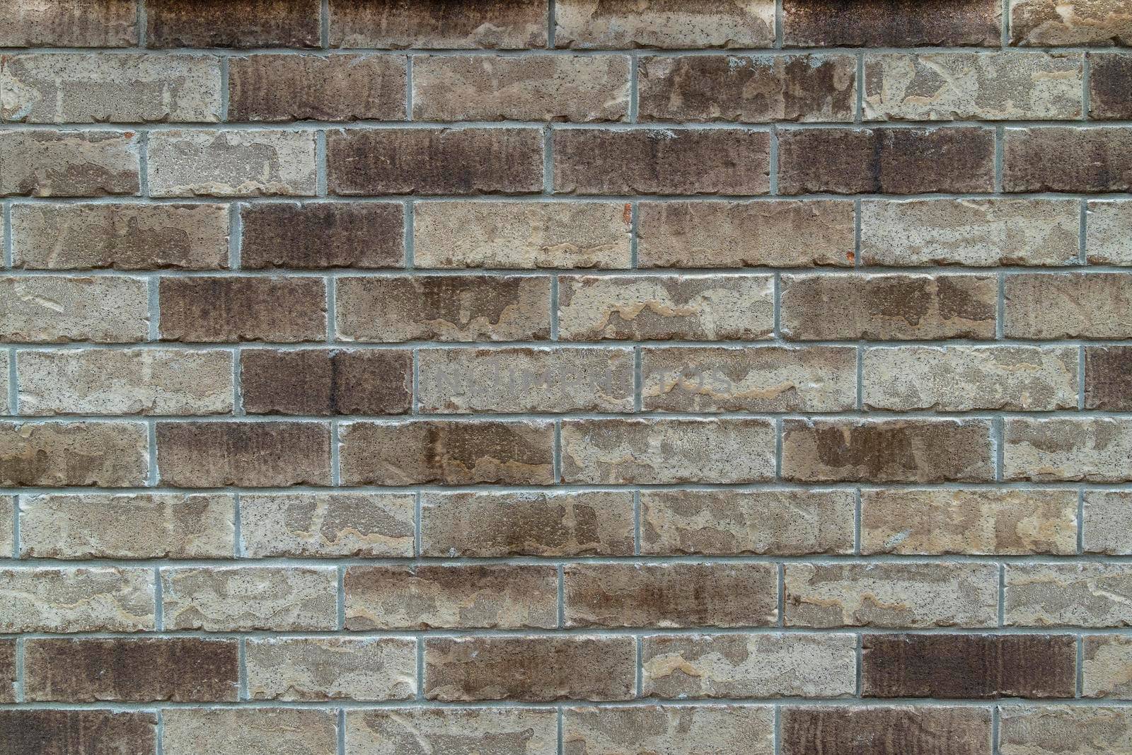Photo of the cladding of a wooden house made of gray bricks