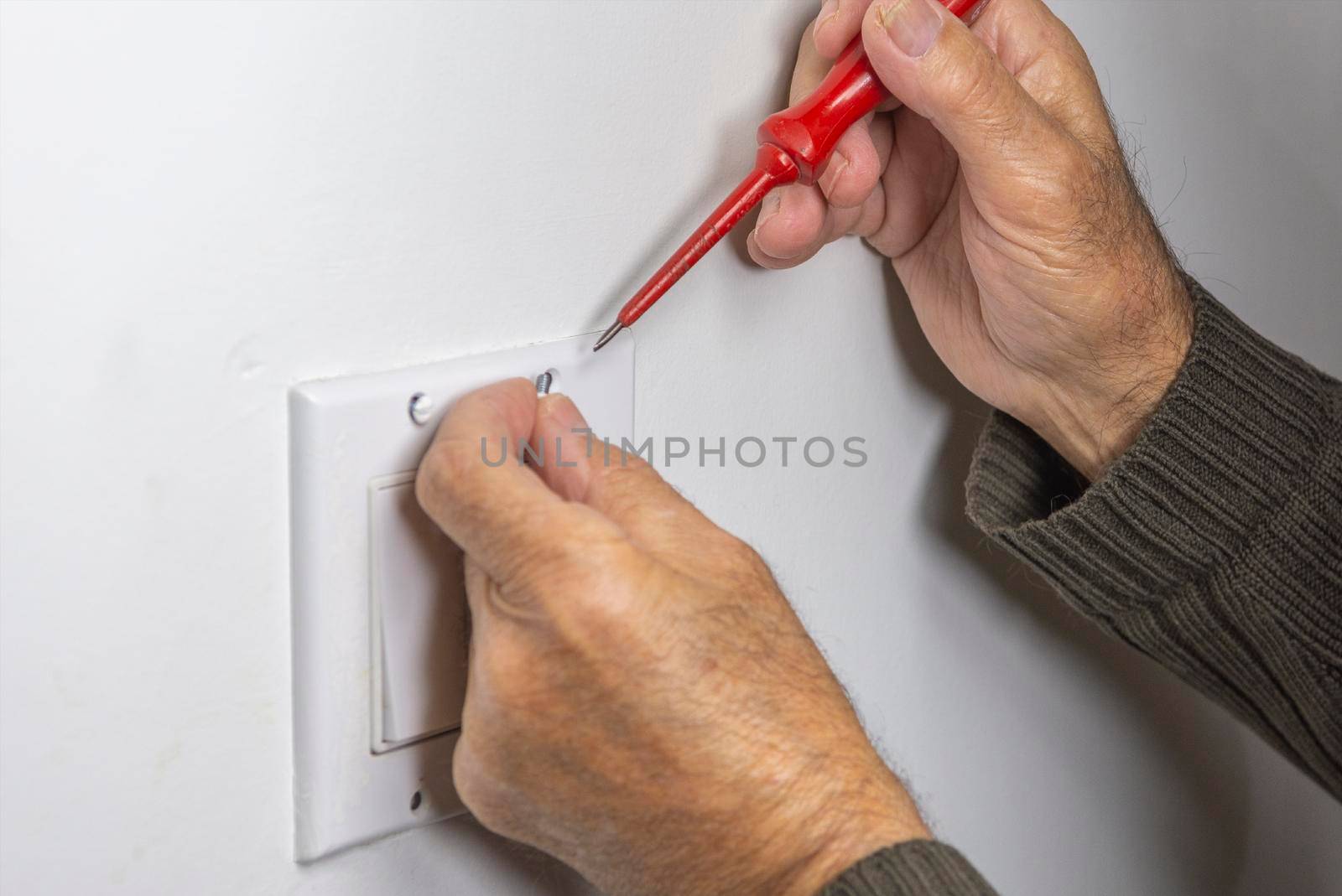 Electrician prepares screws for securing the switch cover by ben44