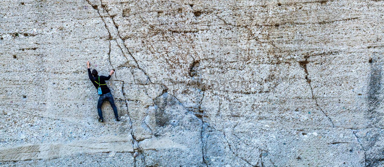 a climber climbs a mountain on a stone cliff. bunner by Edophoto