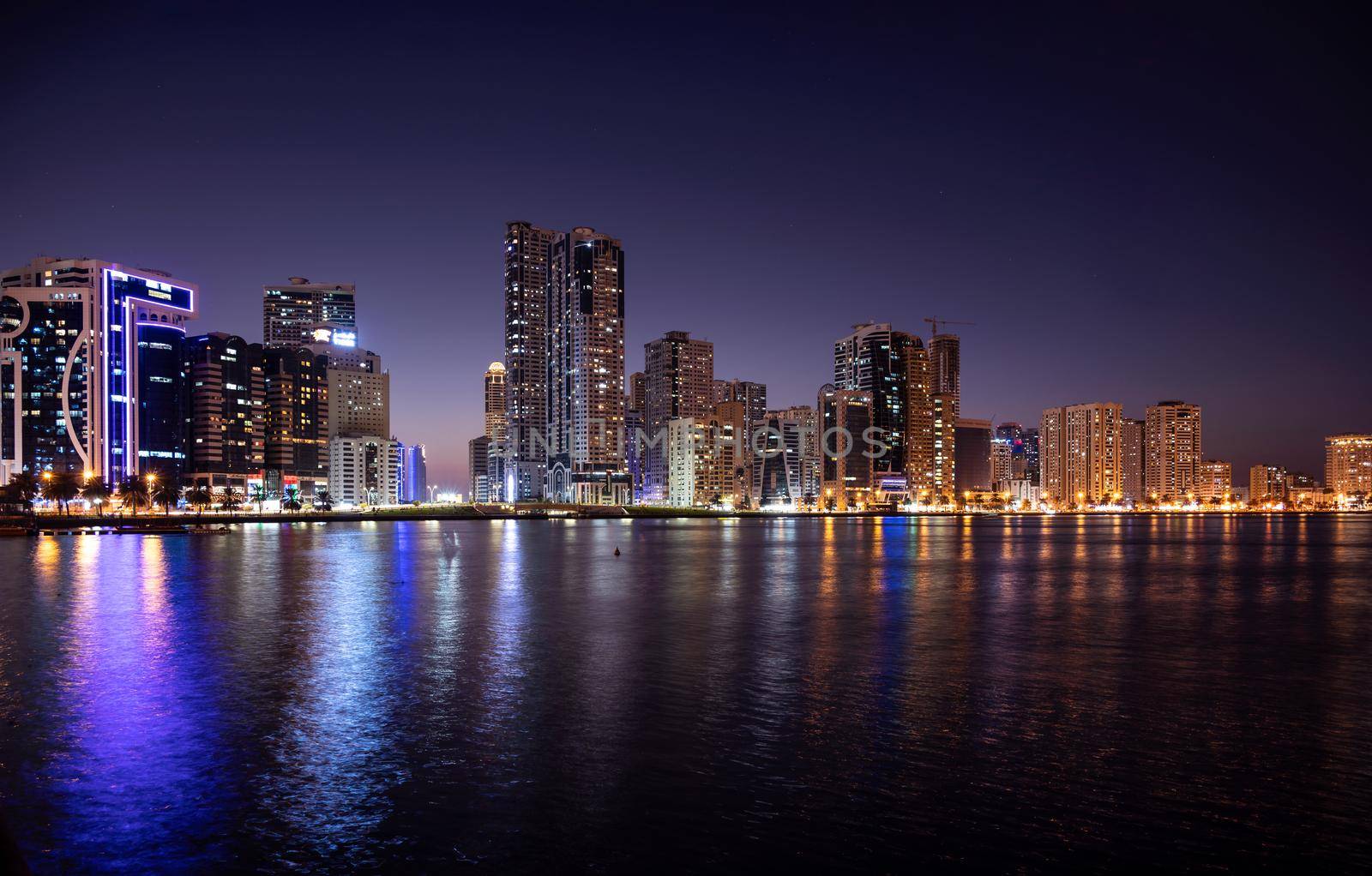 Sharjah,UAE - Dec 2nd 2020. Panoramic view of the illuminated sky scrappers showing beautiful reflections in water captured at the Al Majaz waterfront Sharjah , UAE.