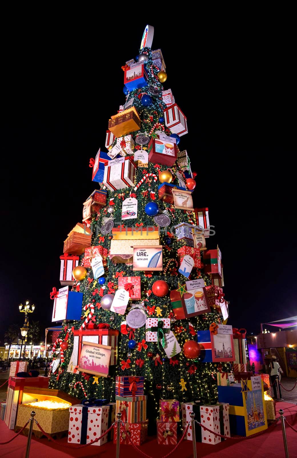 DUBAI, UAE - DECEMBER 16 2020 . Beautifully decorated christmas tree with gifts and lights captured at the park entertainment in the at The Global Village , Dubai,UAE. by sriyapixels