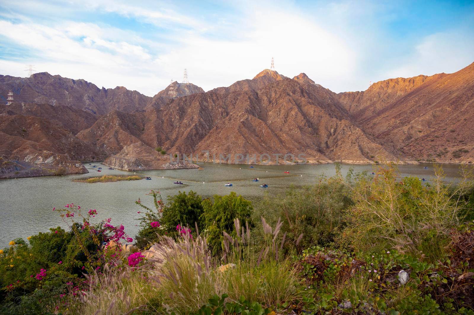 BOATS, KAYAKS IN THE RAFIS WATER DAM AT SUNSET TIME IN THE MOUNTAINS ENCLAVE REGION OF KHOR FAKKAN, SHARJAH UNITED ARAB EMIRATES