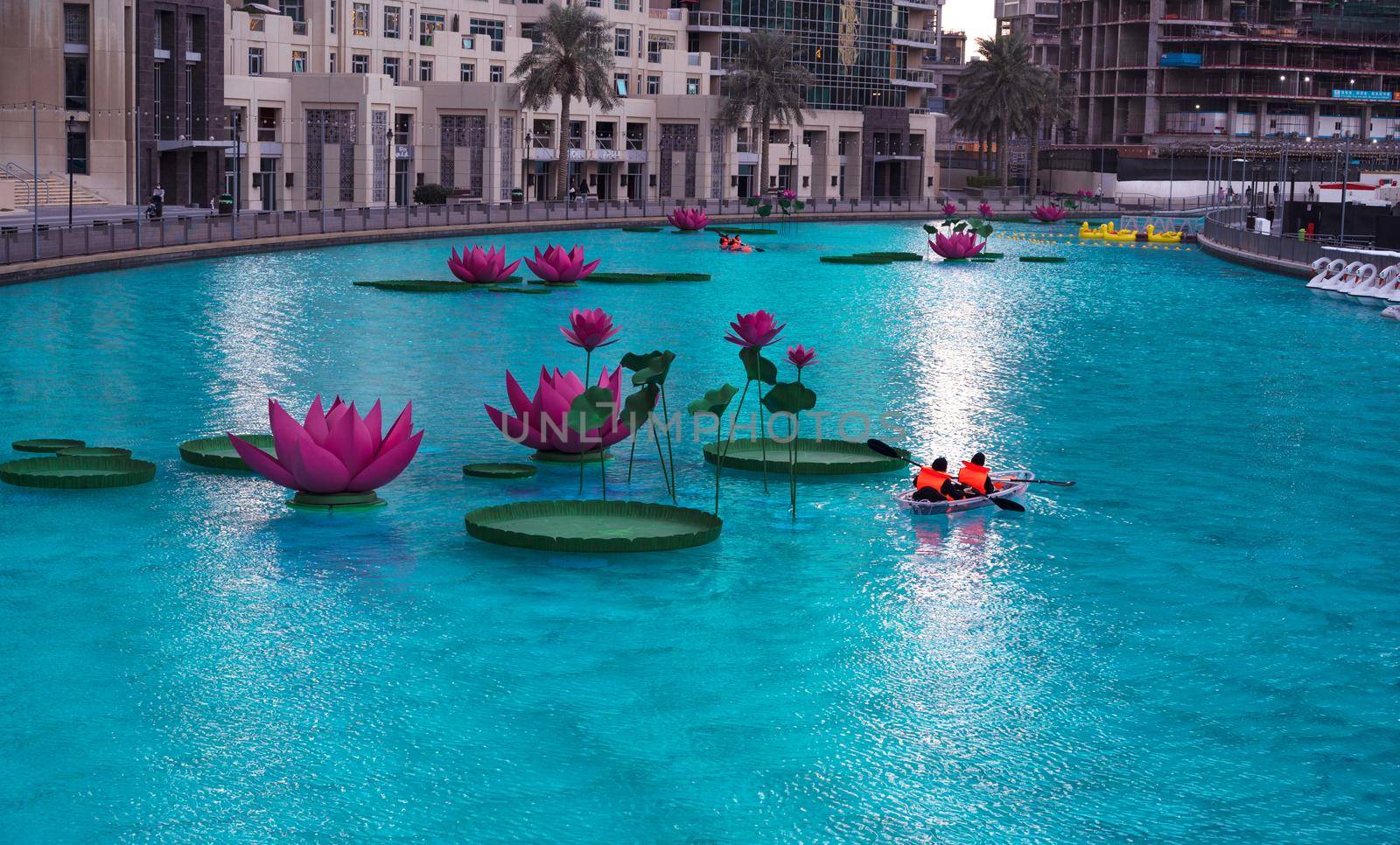 JAN 7th 2021, DUBAI, UAE. TOURISTS RIDING THE BOATS IN THE BEAUTIFUL LOTUS FLOWER POOL AT THE RECREATIONAL BOULEVARD AREA OF THE BURJ PARK, DUBAI,UAE.