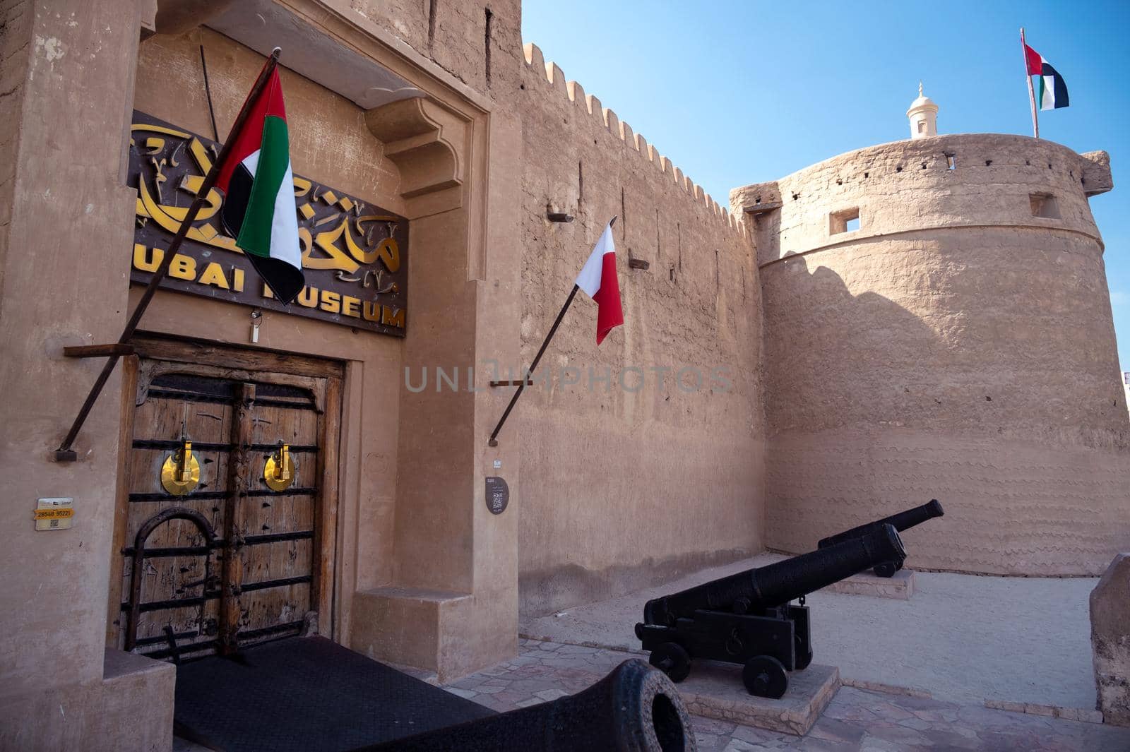 Feb 27th, 2021, Bur Dubai, UAE. View of the old Vintage door,canons and signboard at the entrance to the museum of Dubai UAE captured at Bur Dubai, UAE. by sriyapixels