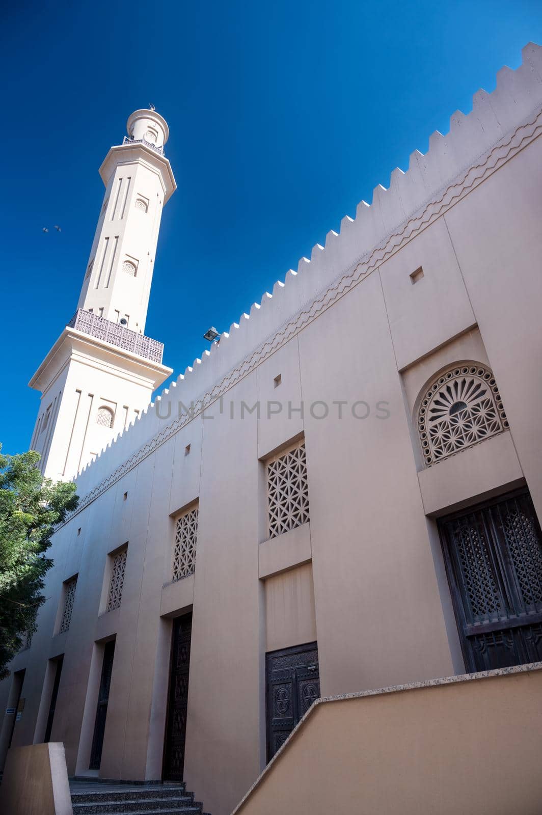 Feb 27th, 2021, Bur Dubai, UAE. View of the old Grand Mosque with beautiful minarets and wooden door captured at Bur Dubai, UAE. by sriyapixels