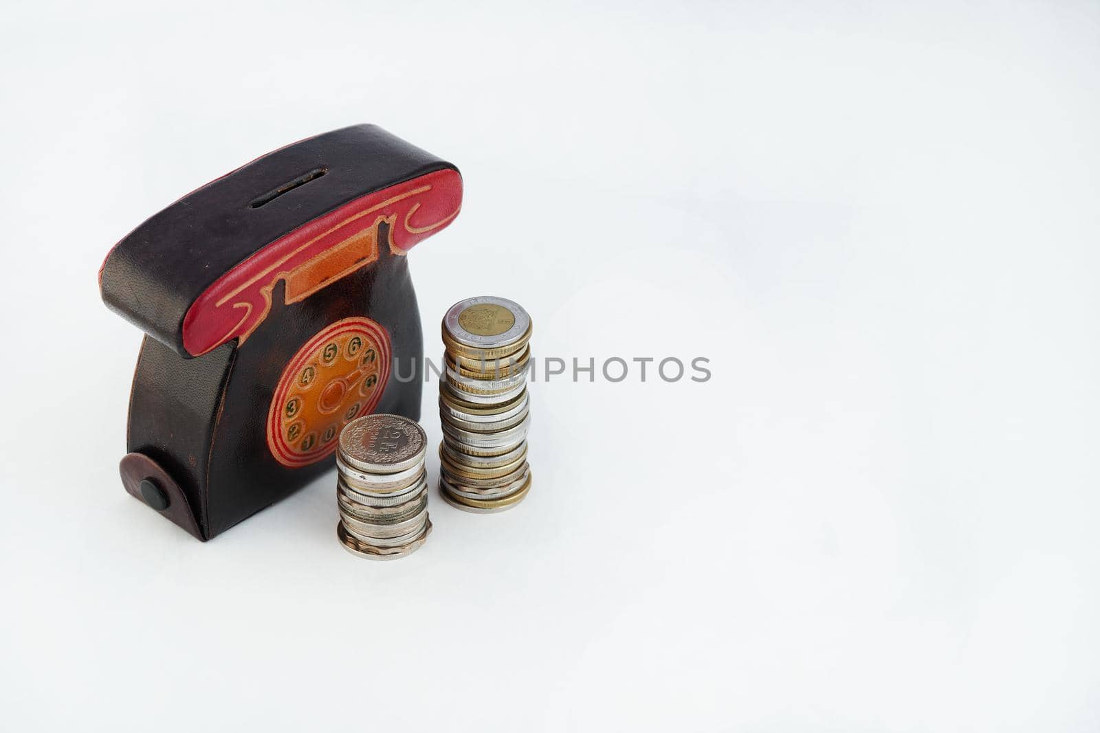 A money box with coins is isolated on a white background with a place for an inscription. High quality photo