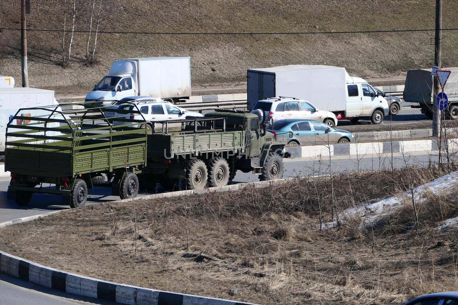 Passenger transport and a military vehicle on the city road. by Olga26