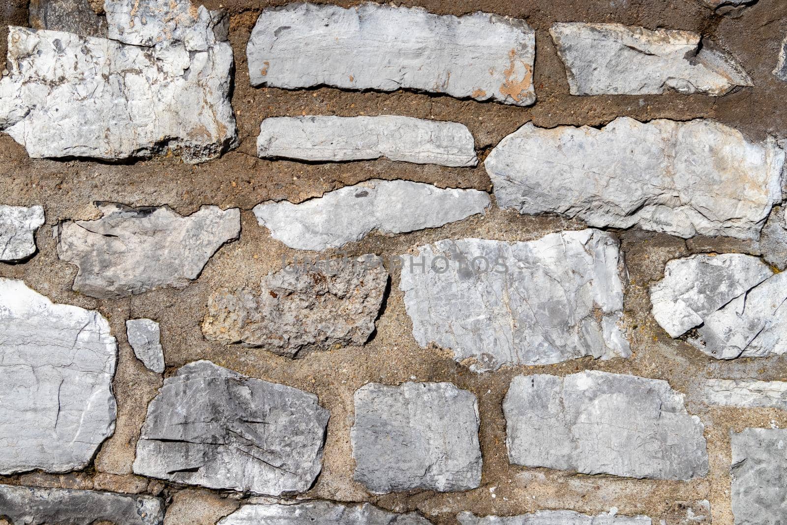 Grey stone wall from an historic castle as texture and background by reinerc