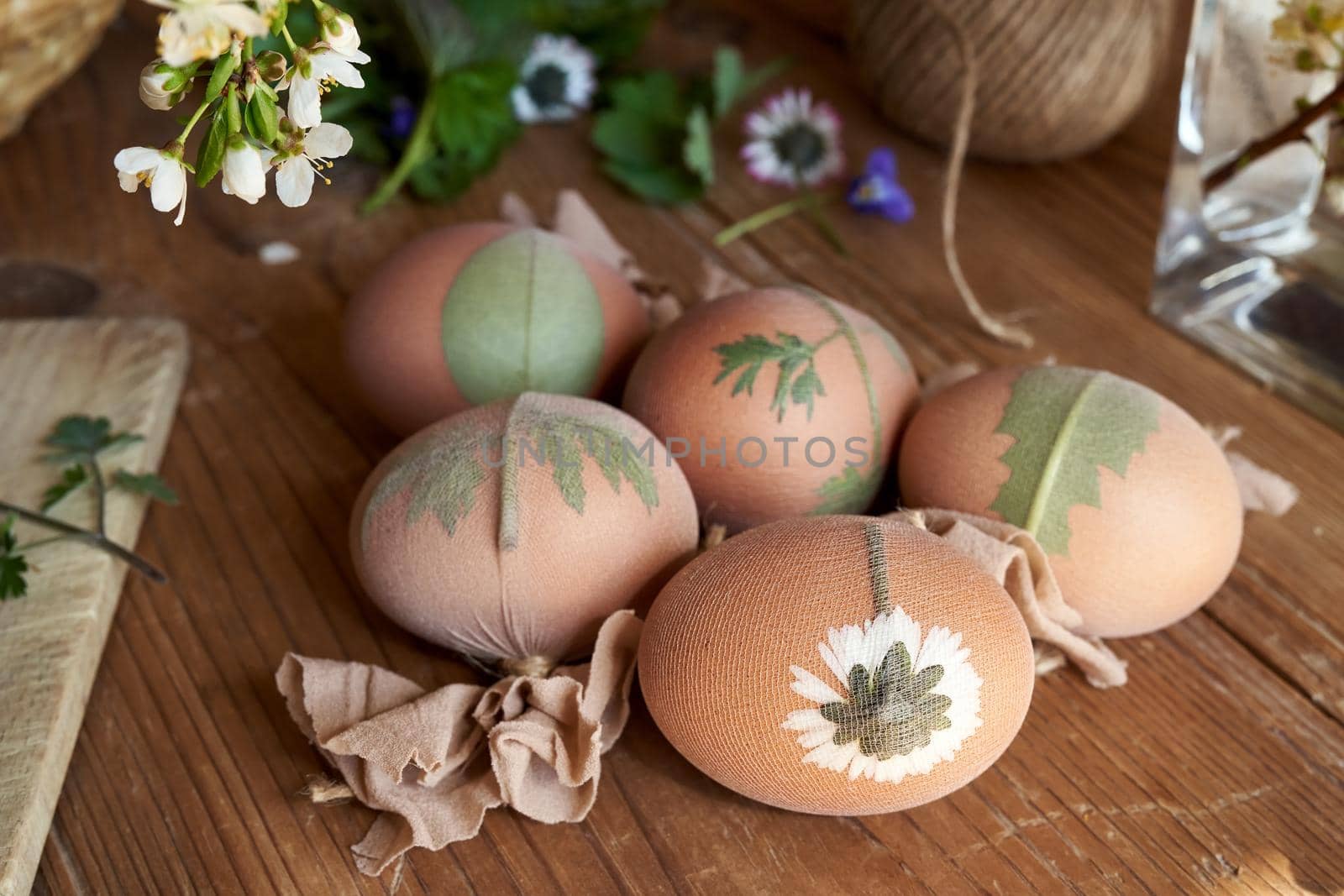 Easter eggs with fresh leaves attached to them, ready to be dyed with onion peels