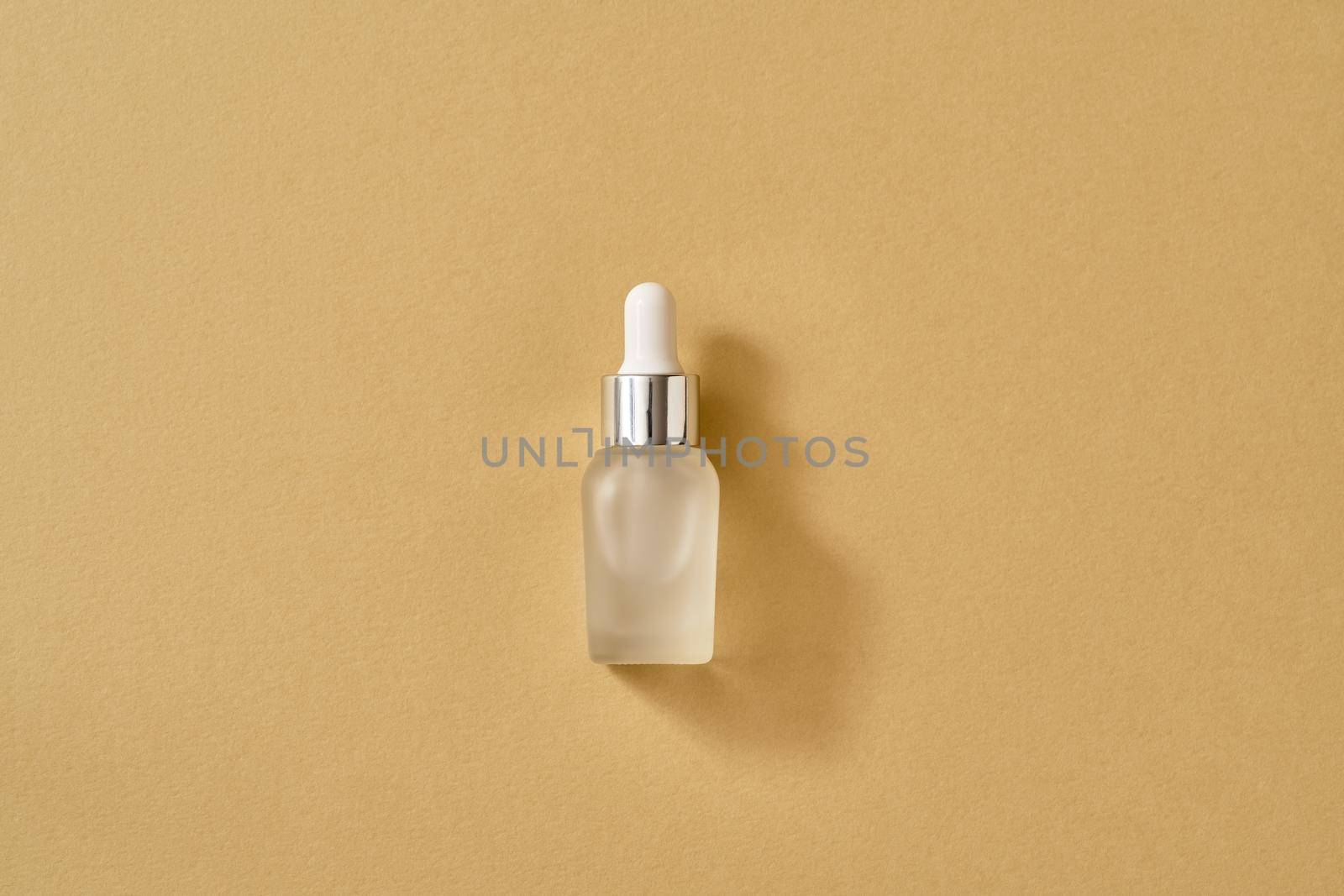 A bottle of essential oil on beige background  by madeleine_steinbach