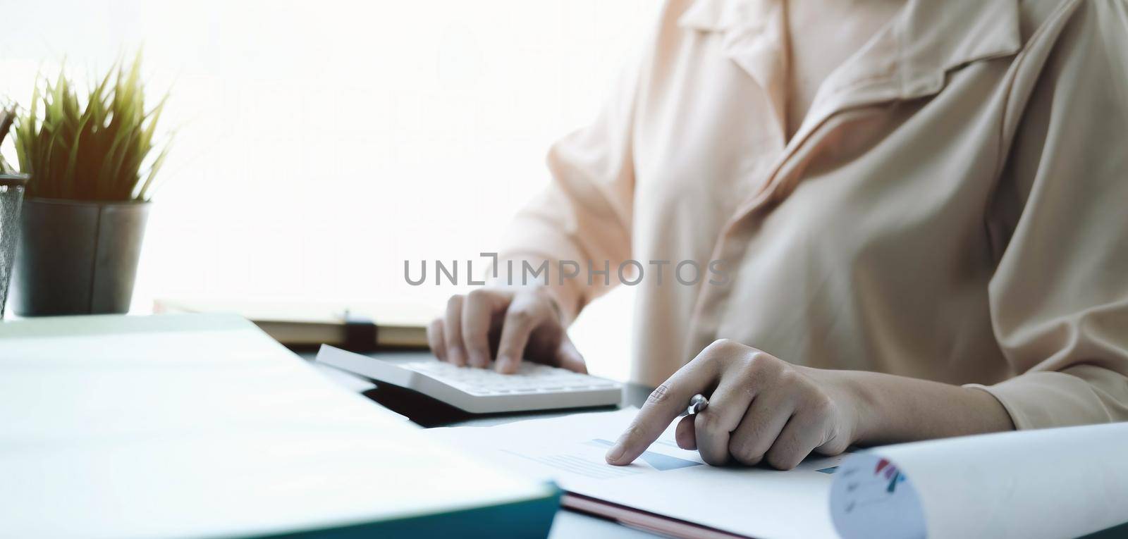 Close up Business woman using calculator and laptop for do math finance on wooden desk in office and business working background tax accounting statistics
