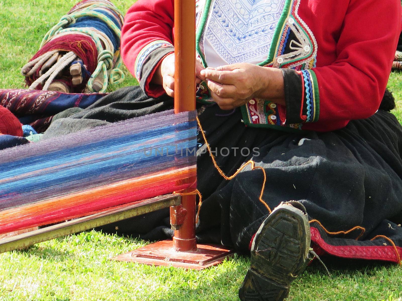 Close up of Peruvian lady in authentic dress spinning yarn by hand by aroas