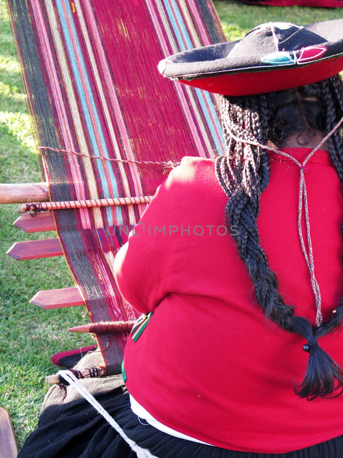 Close up of Peruvian lady in authentic dress spinning yarn by hand. (Peru)