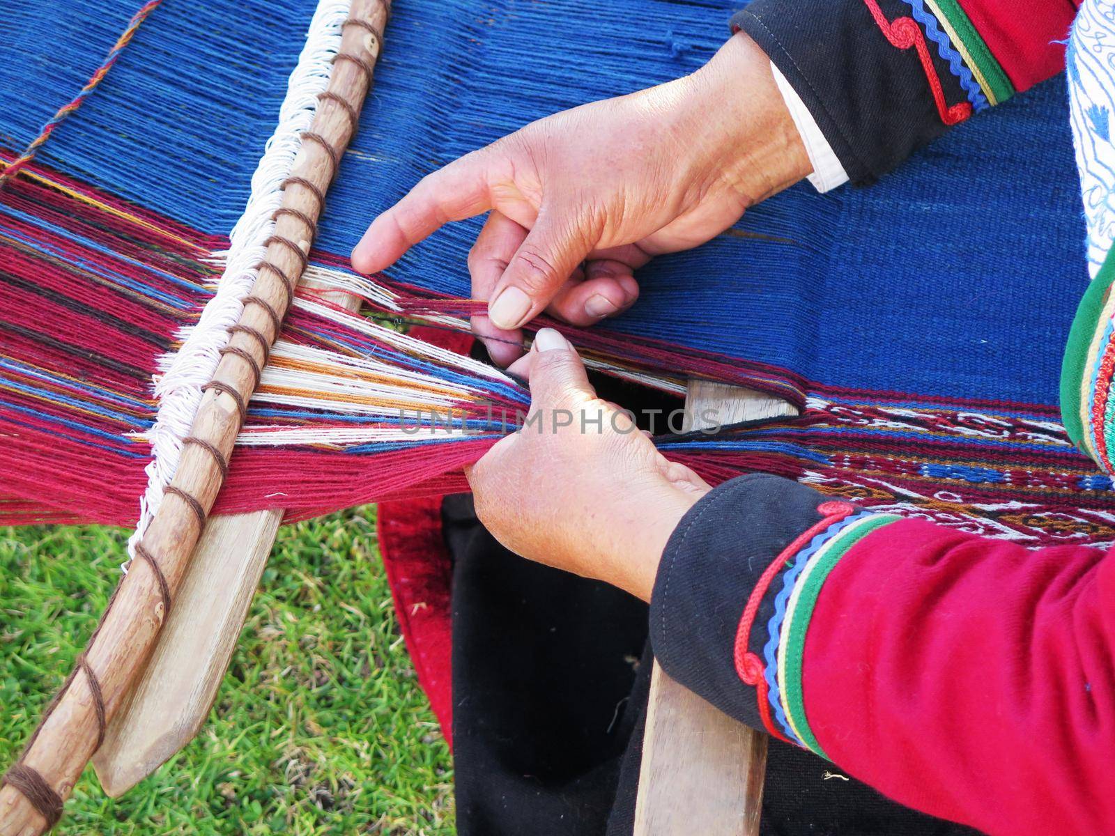 Close up of Peruvian lady in authentic dress spinning yarn by hand by aroas