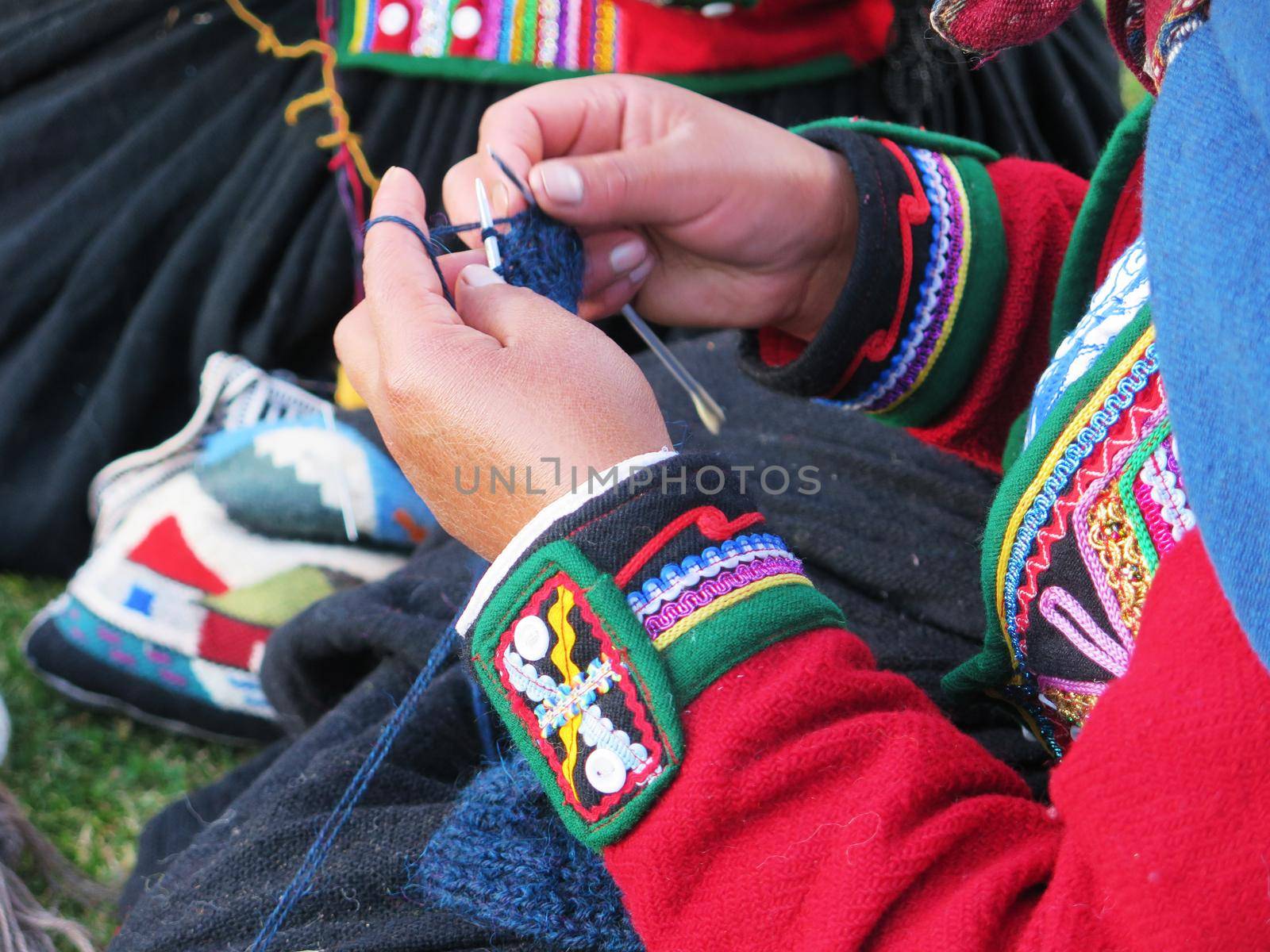 Close up of Peruvian lady in authentic dress spinning yarn by hand. (Peru)