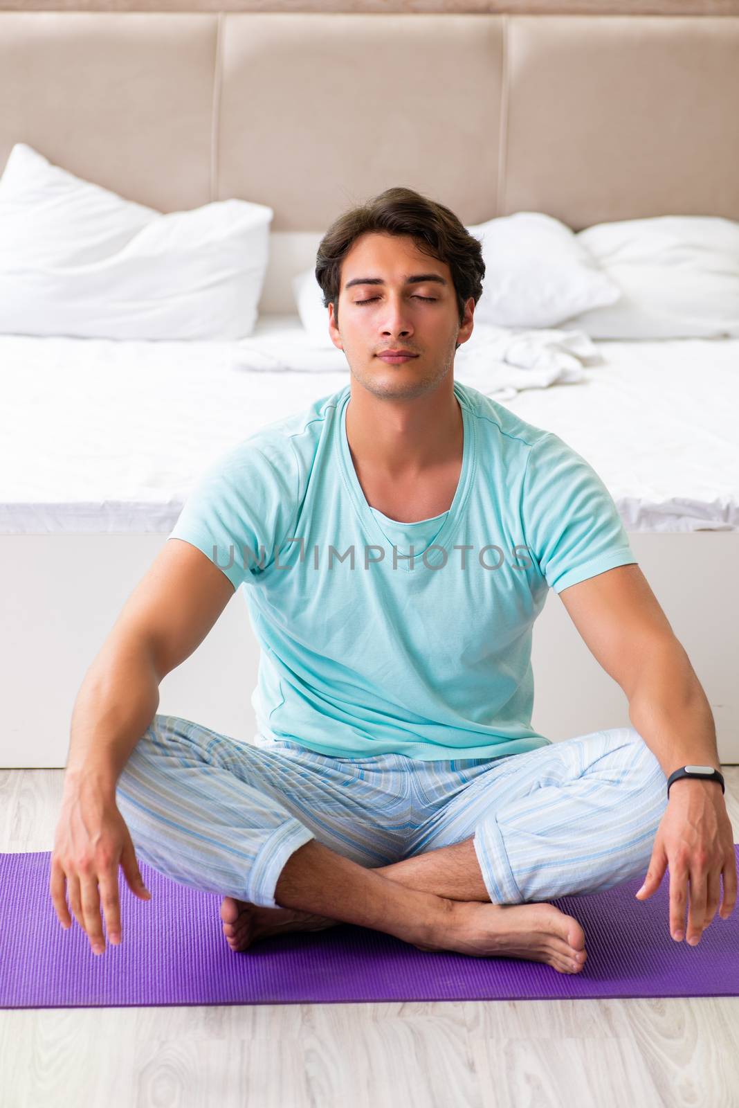 Young man in pajamas doing morning exercises 