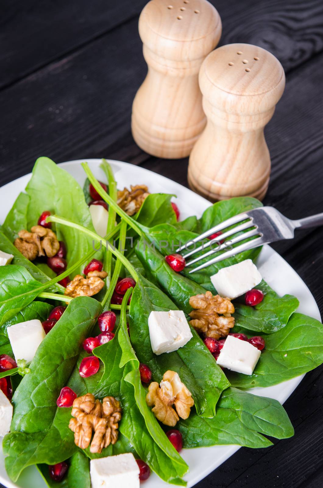 Spinach salad with nuts and apples served on table