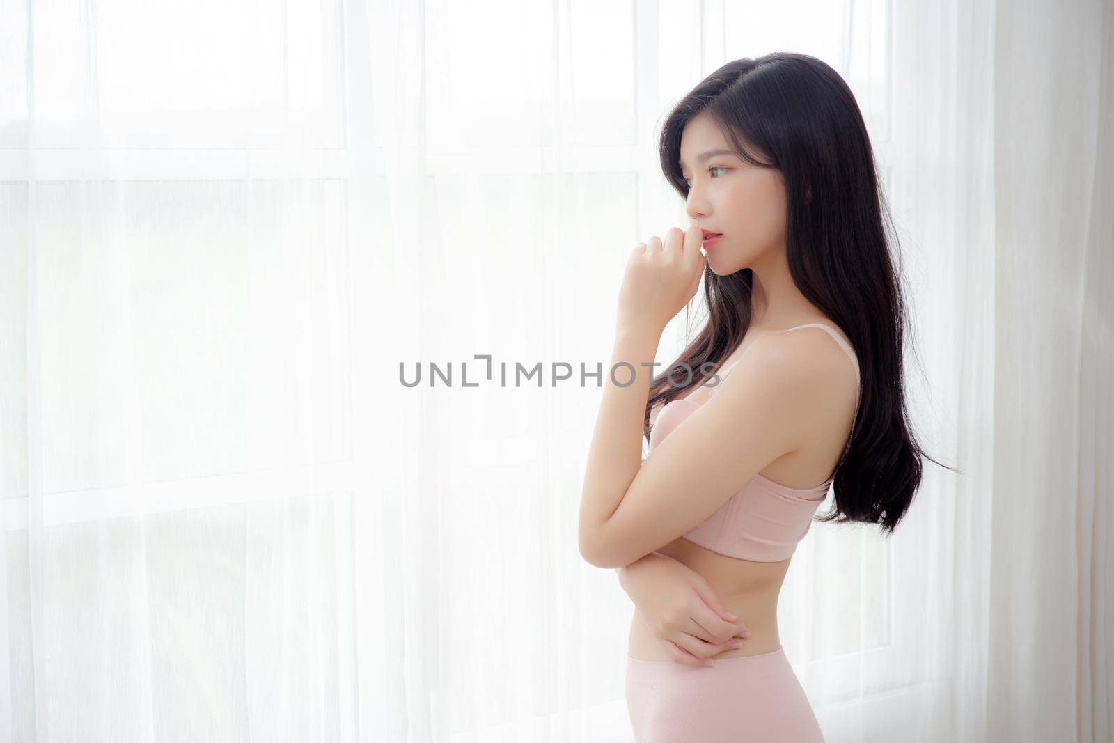 Beautiful portrait young asian woman sexy thinking idea weight loss near the windows for healthy, body of asia girl happy with diet and cheerful with wellbeing, lifestyle and relax concept.