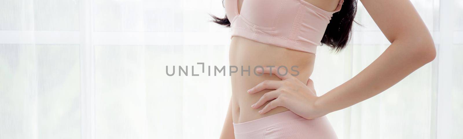 Closeup asian woman wear underwear beautiful body belly slim shape sexy with diet at room, asia girl wear bra hand touch abdomen thin with weight loss, health and wellness concept, banner website.