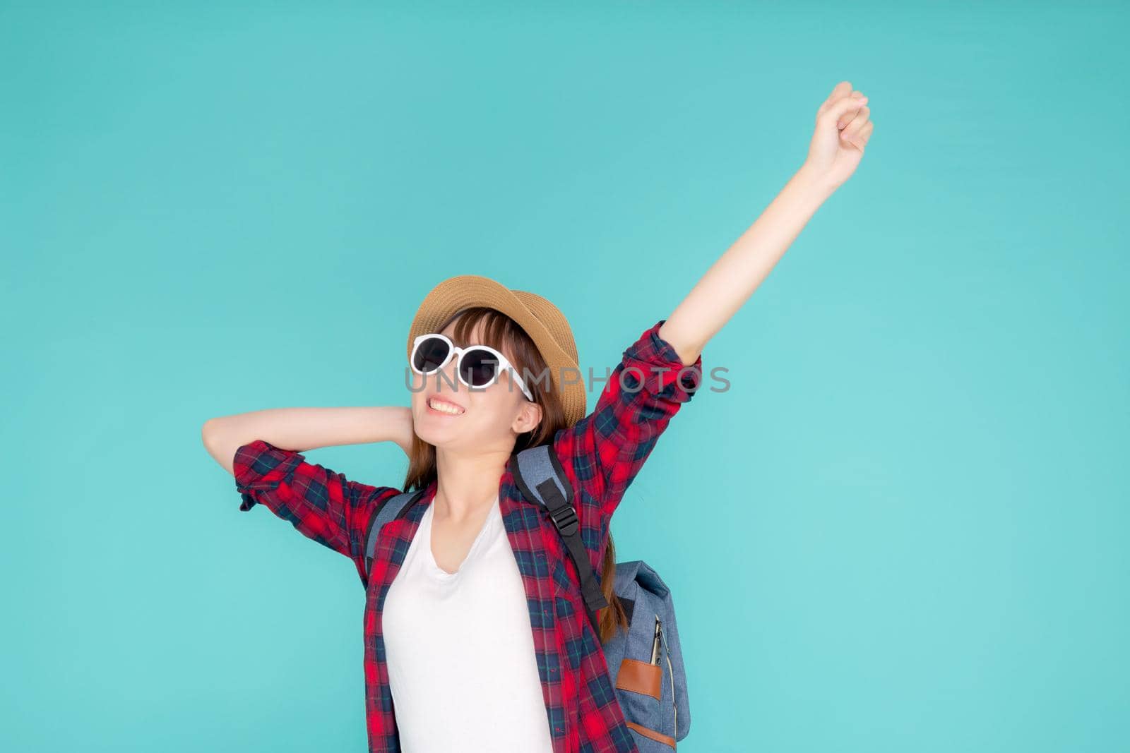 Beautiful portrait young asian woman wear sunglasses and hat smile excited and confident enjoy summer trip holiday isolated blue background, girl cheerful having backpack in vacation, travel concept.