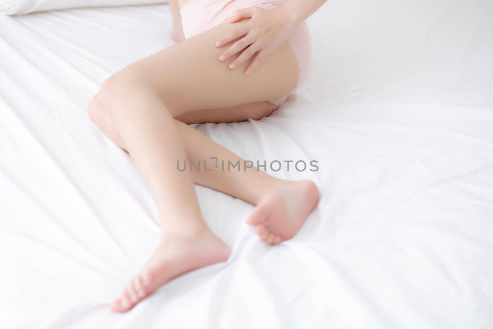 Beautiful young asian woman touch skin leg smooth with cream and lotion for hydration and smooth, girl applying body care and cosmetic for silky and soft, beauty perfect with wellness, health and care.