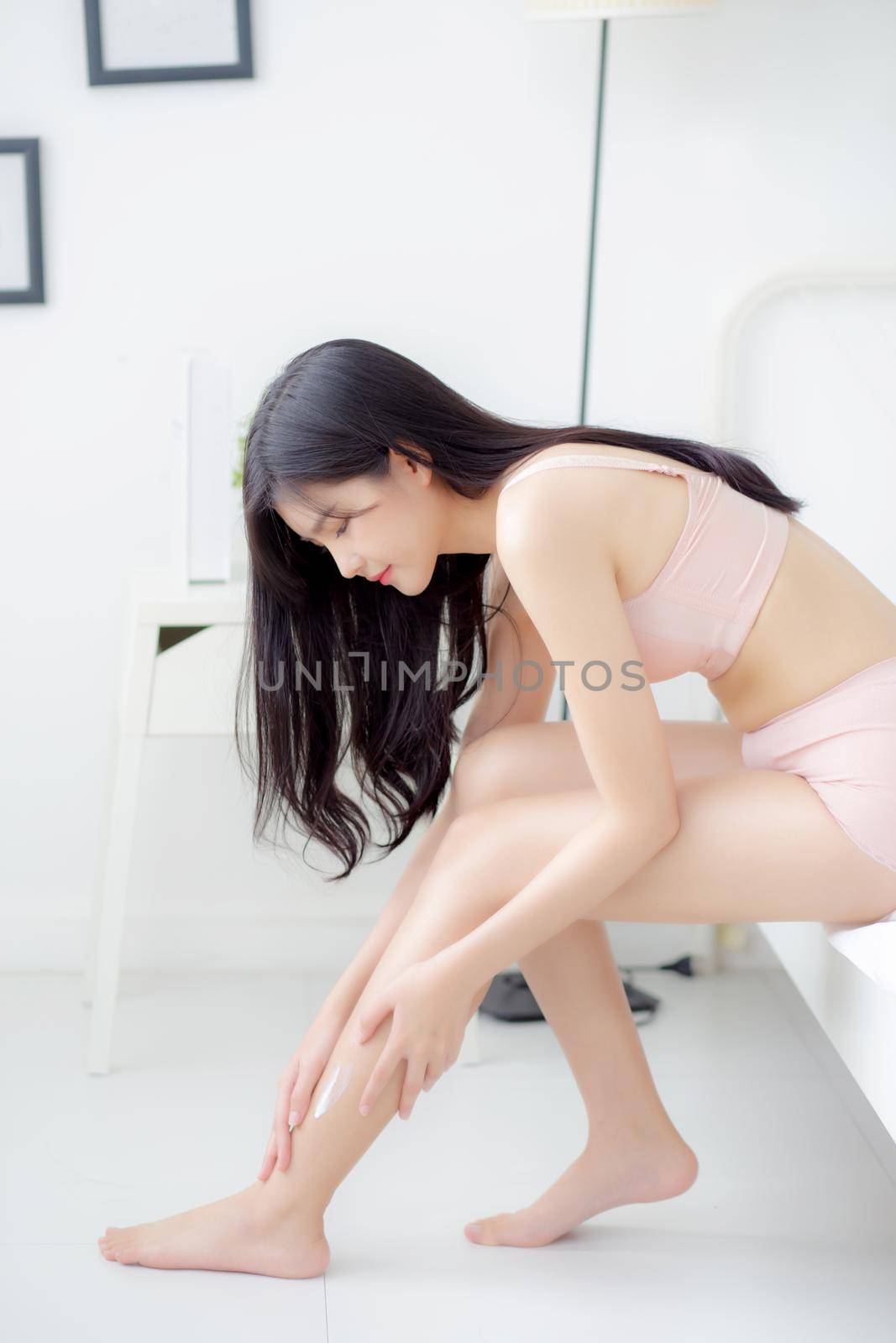 Beautiful young asian woman touch skin leg smooth with cream and lotion for hydration and smooth, girl applying body care and cosmetic for silky and soft, beauty perfect with wellness, health and care. by nnudoo